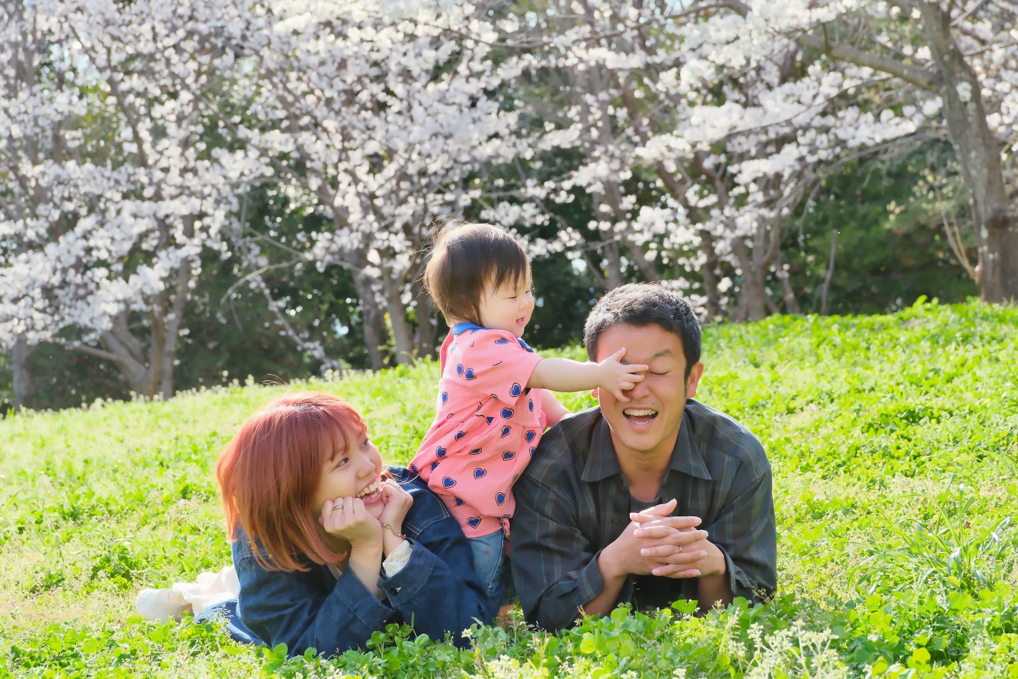 お母さんとお父さんに抱っこされた子ども