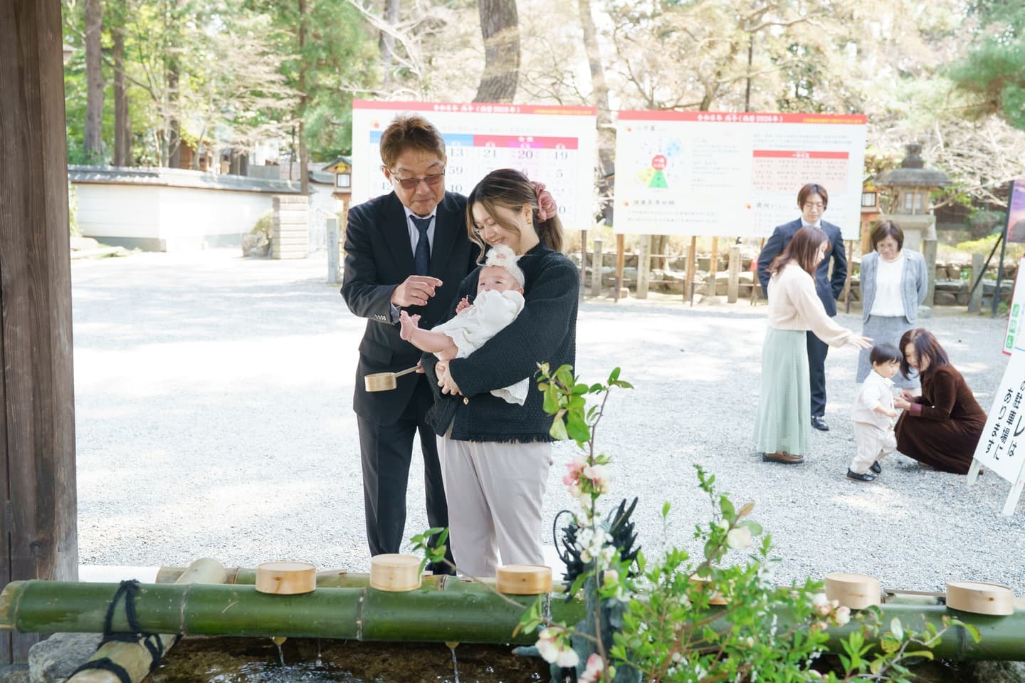 神社でお宮参りの赤ちゃんと家族