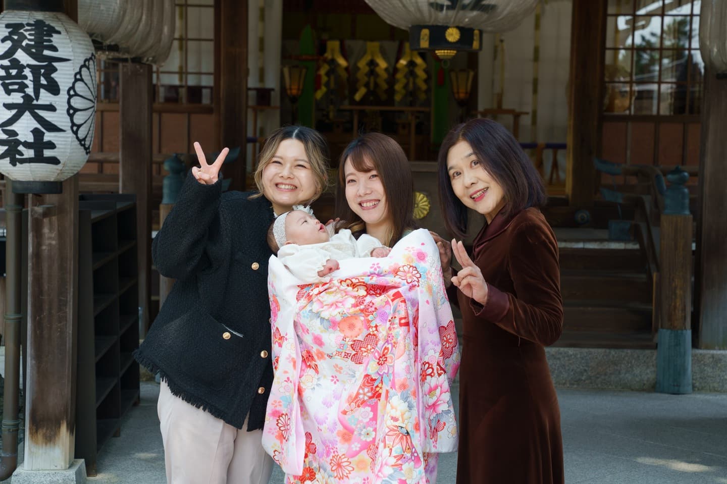 神社でお宮参りの赤ちゃんと家族