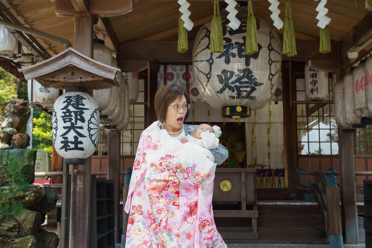 神社でお宮参りの赤ちゃんと家族