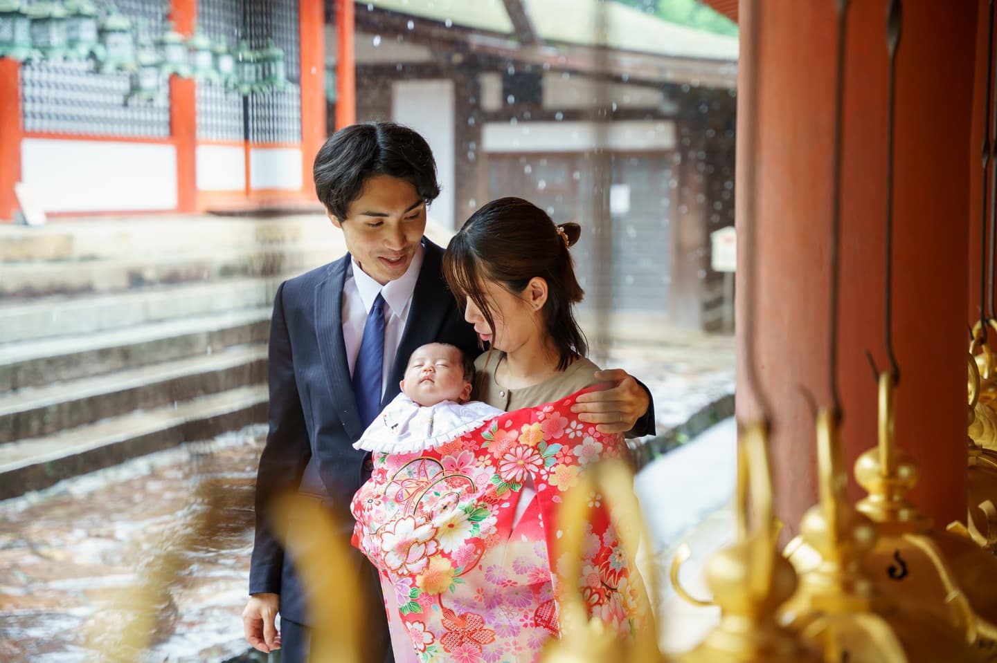 神社でお宮参りの赤ちゃんと家族
