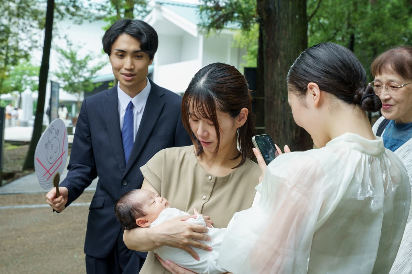 神社でお宮参りの赤ちゃんと家族
