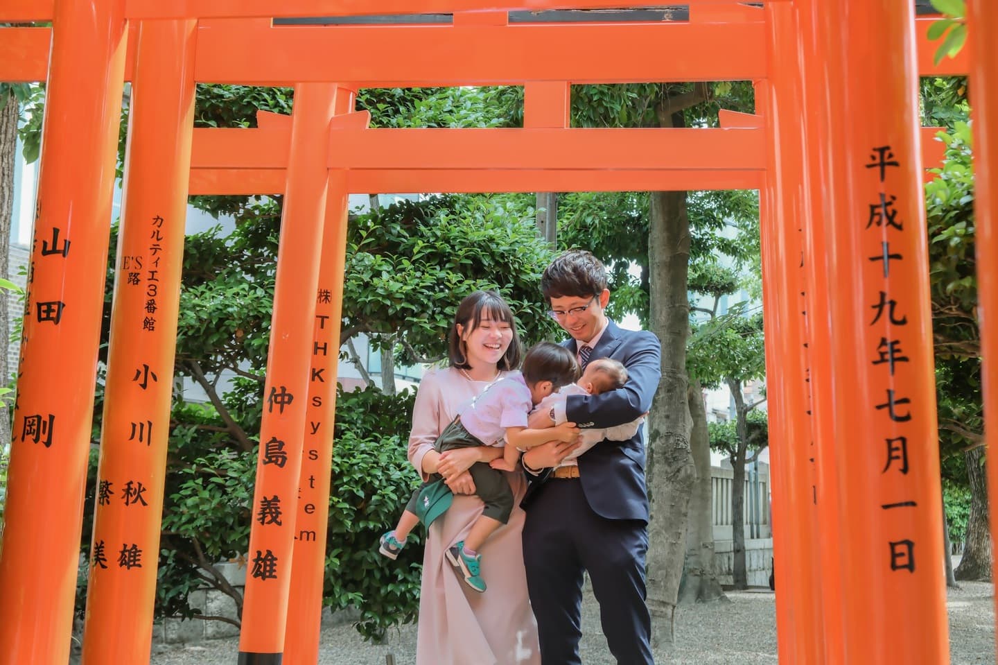 神社でお宮参りの赤ちゃんと家族