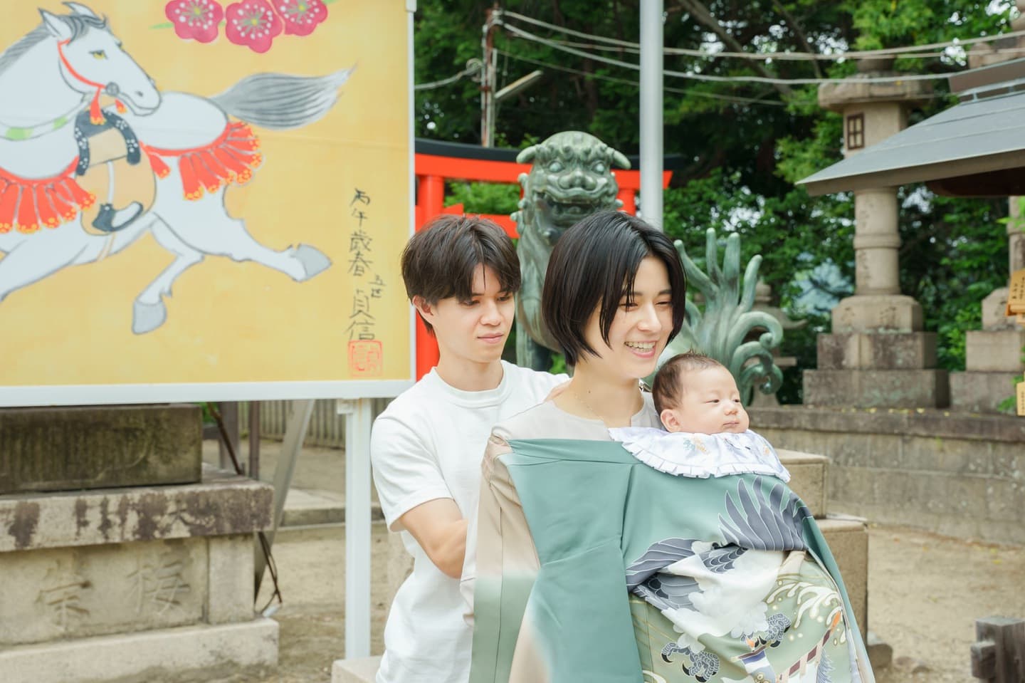 神社でお宮参りの赤ちゃんと家族