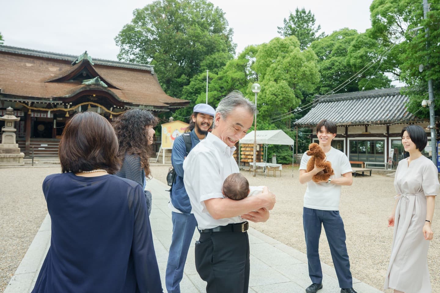 神社でお宮参りの赤ちゃんと家族