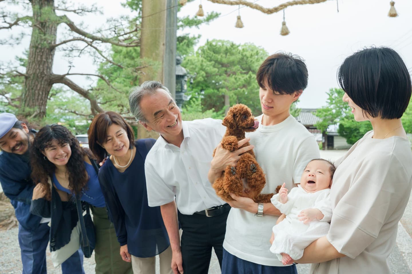神社でお宮参りの赤ちゃんと家族
