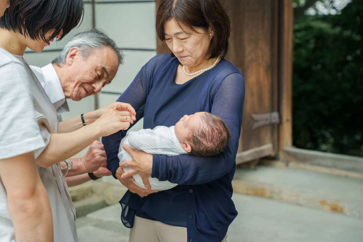 神社でお宮参りの赤ちゃんと家族