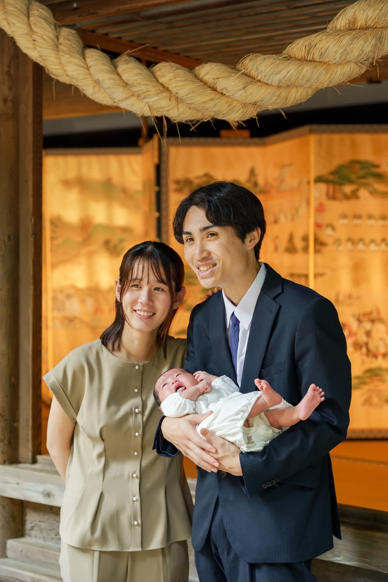 神社でお宮参りの赤ちゃんと家族