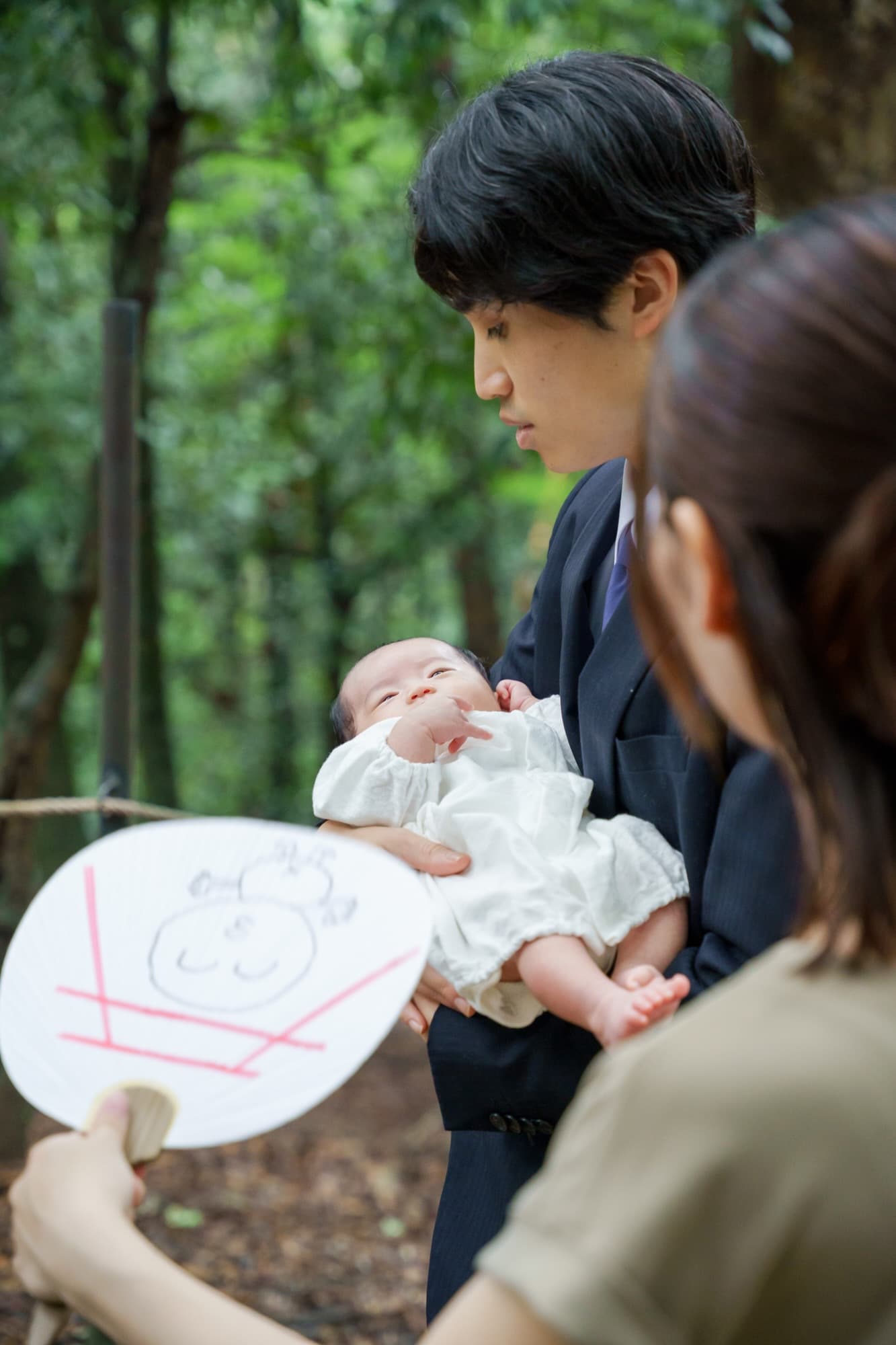 神社でお宮参りの赤ちゃんと家族