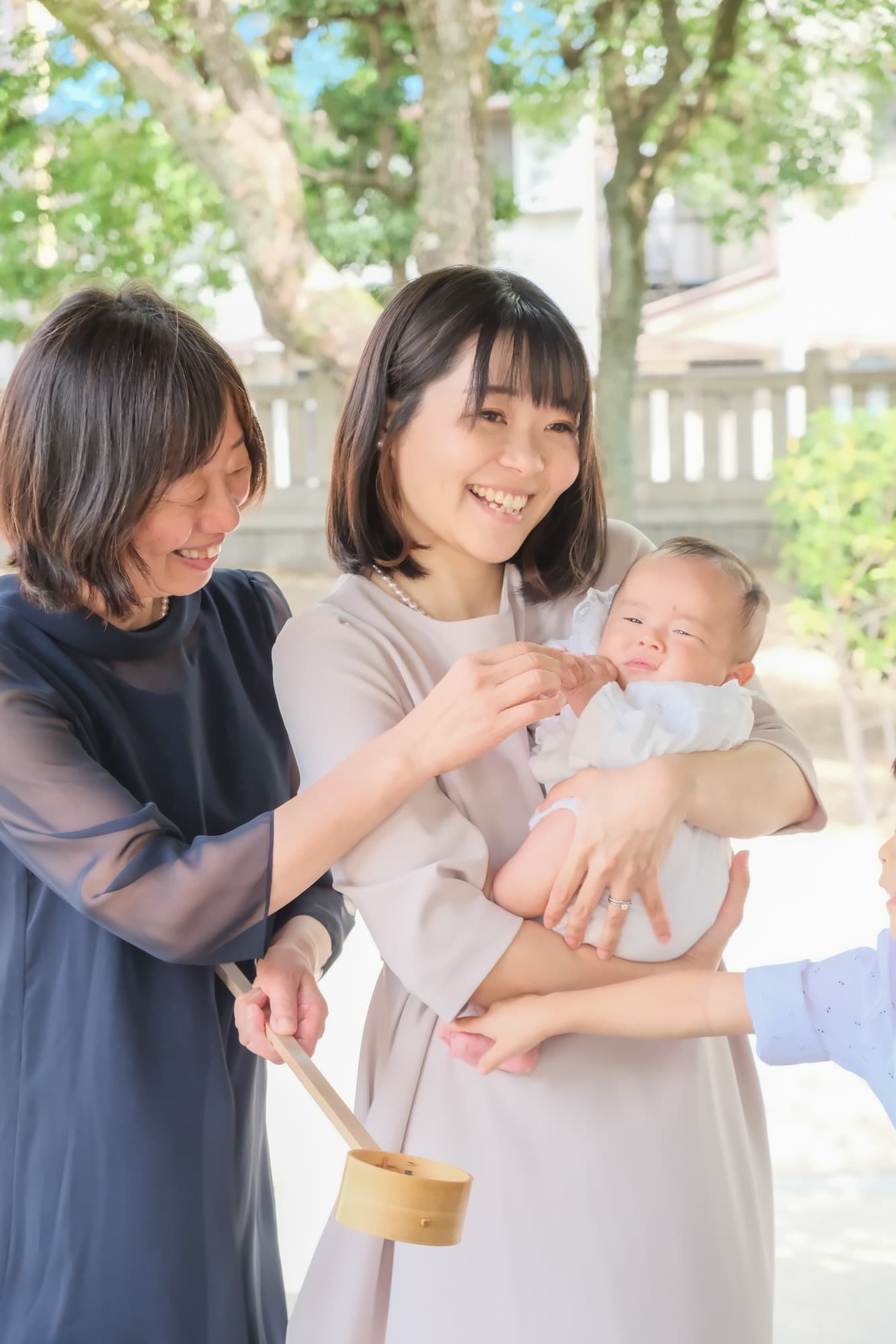 神社でお宮参りの赤ちゃんと家族