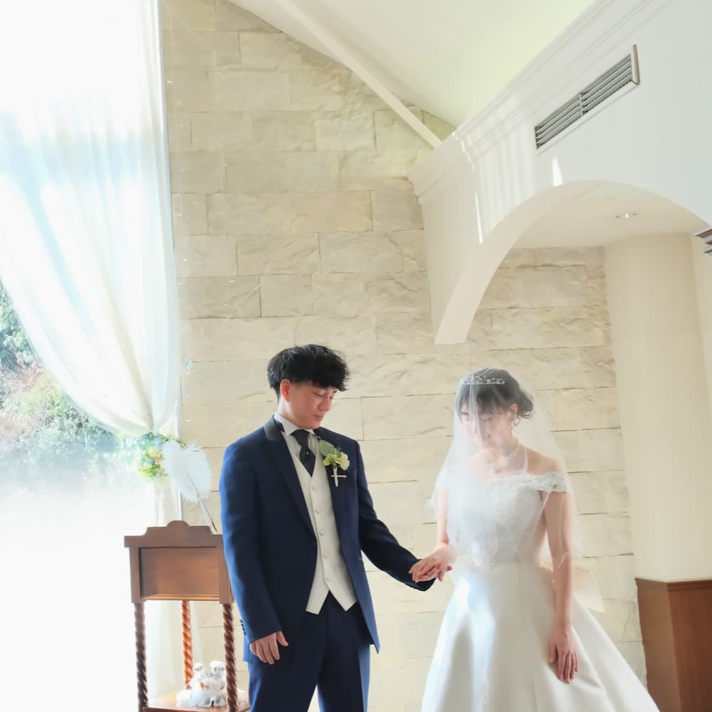ウェディングを行っているウェディングドレスを着た花嫁様とタキシードを着た新郎様