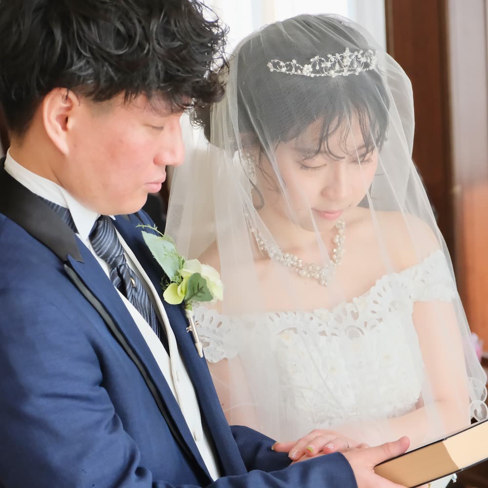 ウェディングを行っているウェディングドレスを着た花嫁様とタキシードを着た新郎様