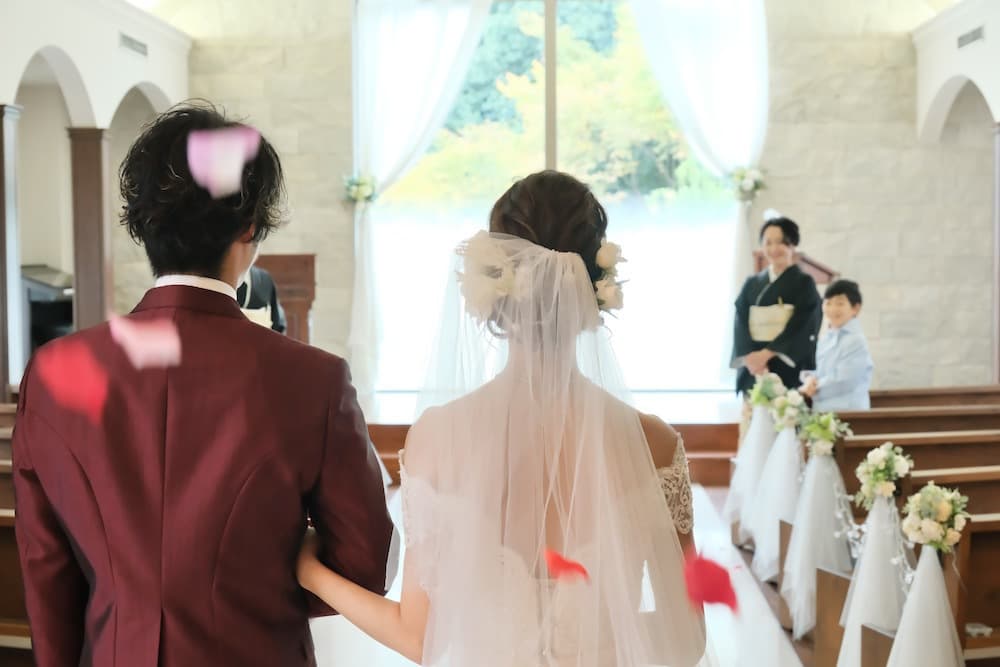 フラワーシャワーの花びらが、舞い散る中に立っている新郎新婦