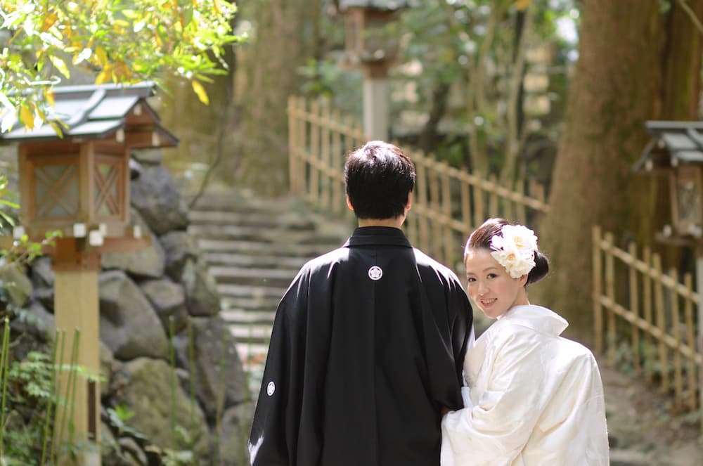 白無垢の花嫁様と紋付羽織袴の新郎様が結婚式を挙げている