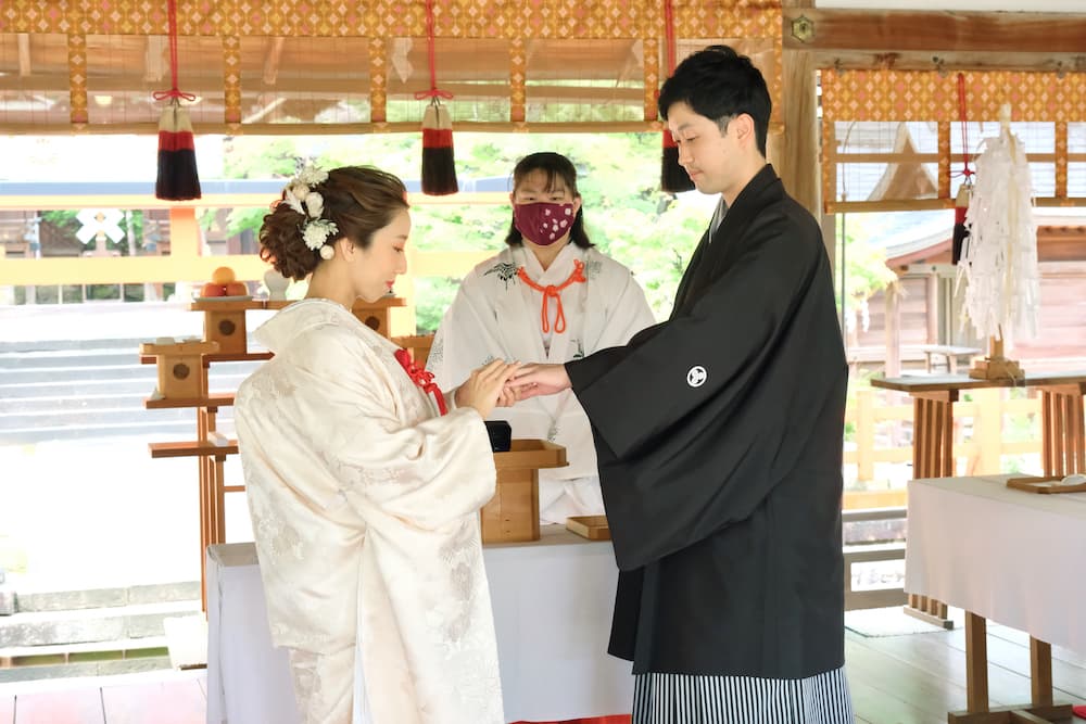 白無垢の花嫁様と紋付羽織袴の新郎様が結婚式を挙げている