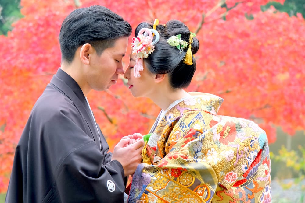 色打掛の花嫁様と紋付羽織袴の新郎様が結婚式を挙げている