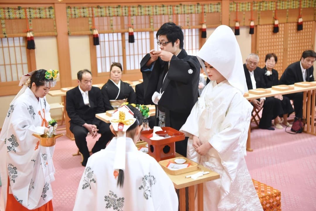 大神神社の神前結婚式で三々九度をする新郎新婦