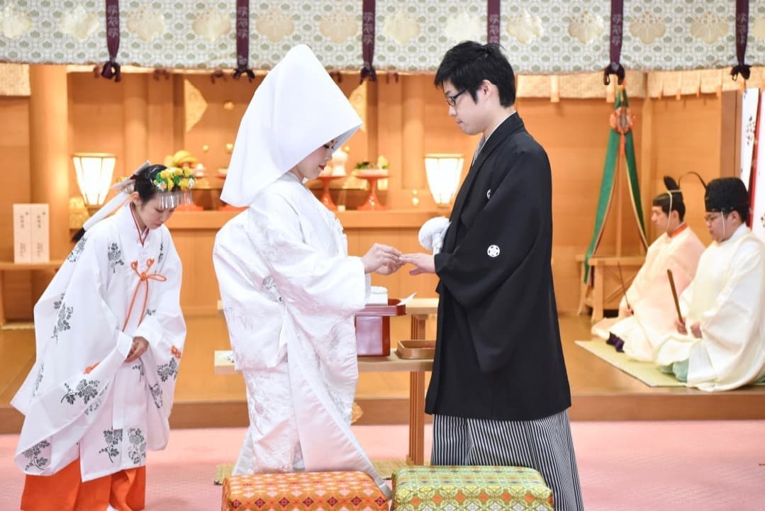大神神社の神前結婚式で指輪を交換する新郎新婦