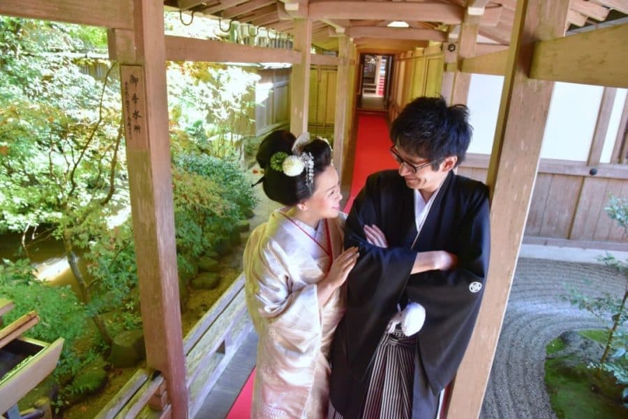 大神神社の境内を歩く白無垢と紋付袴の新郎新婦