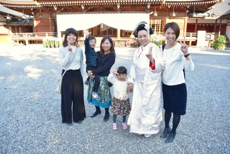 挙式後に家族と記念撮影をする新婦