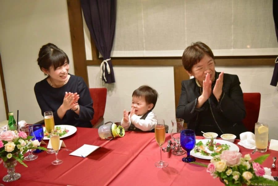結婚式後の食事会で談笑する新郎新婦と家族