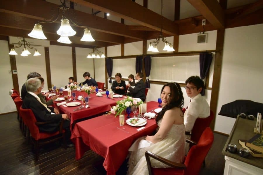結婚式後の食事会で談笑する新郎新婦と家族