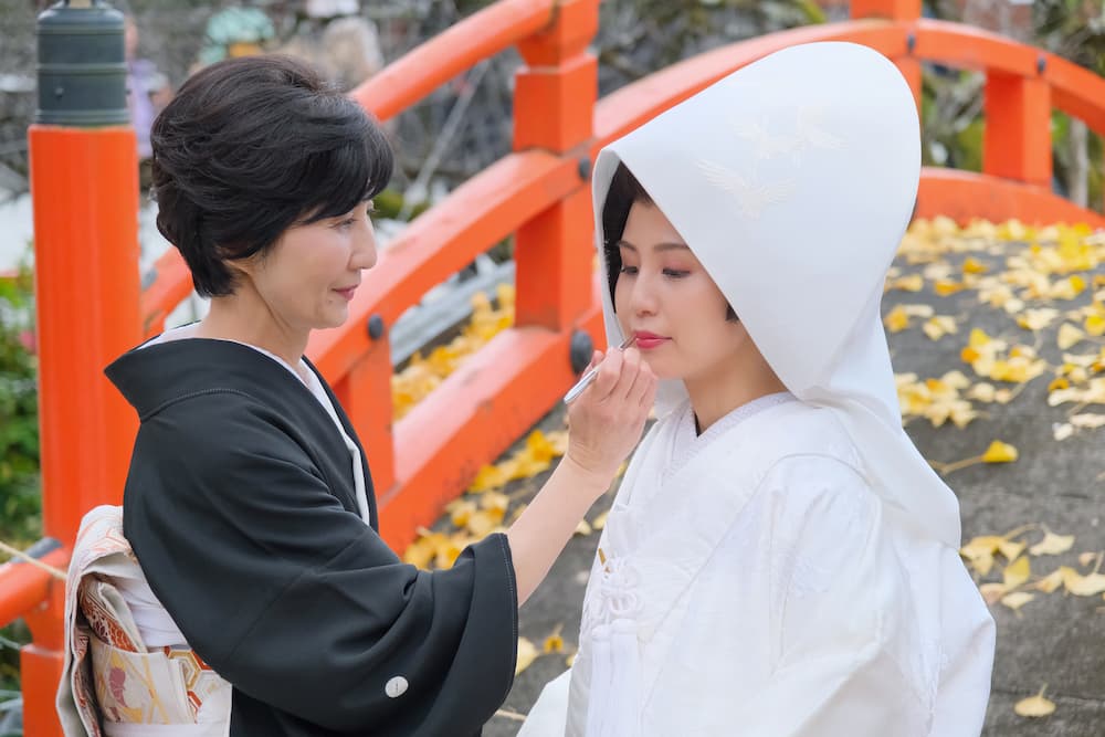 白無垢の花嫁様がお母さんに口紅をさしてもらっている