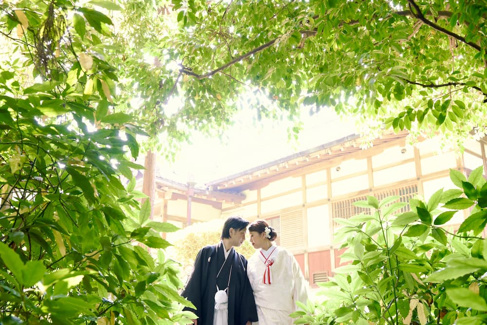 白無垢の花嫁様と紋付羽織袴の新郎様が結婚式を挙げている