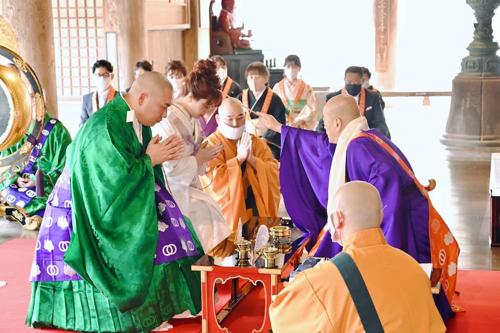 白無垢の花嫁様と紋付羽織袴の新郎様が結婚式を挙げている