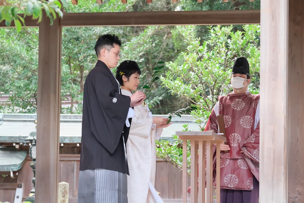 白無垢の花嫁様と紋付羽織袴の新郎様が結婚式を挙げている