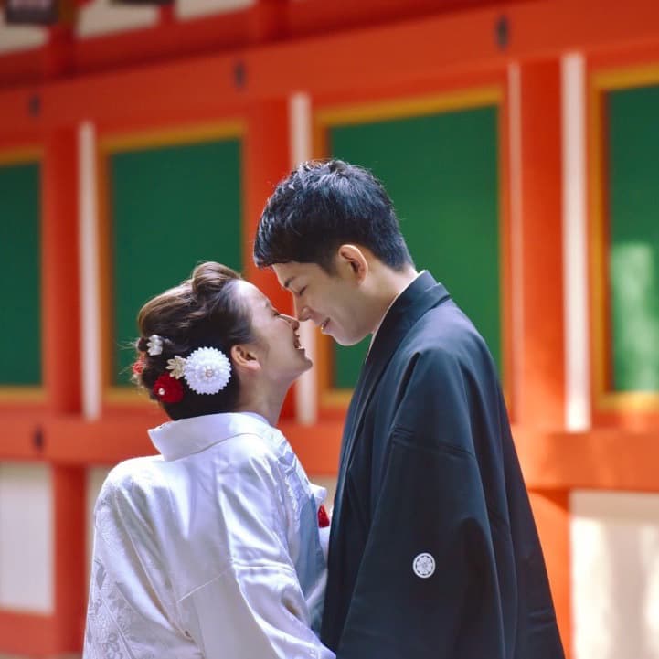 白無垢を着た花嫁様と紋付羽織袴を着た新郎様が顔をくっつけている