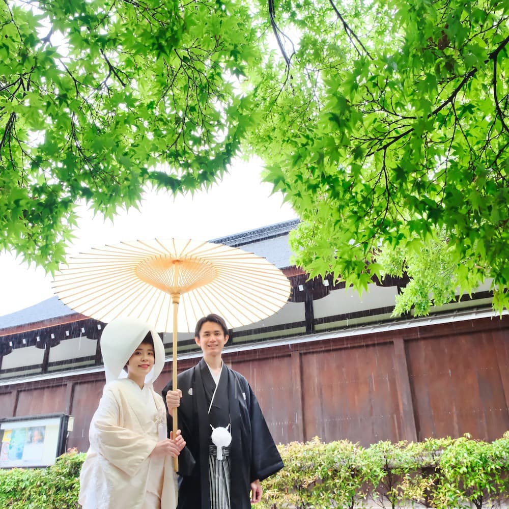 白無垢を着た花嫁様と紋付羽織袴を着た新郎様が神社で結婚式を挙げている