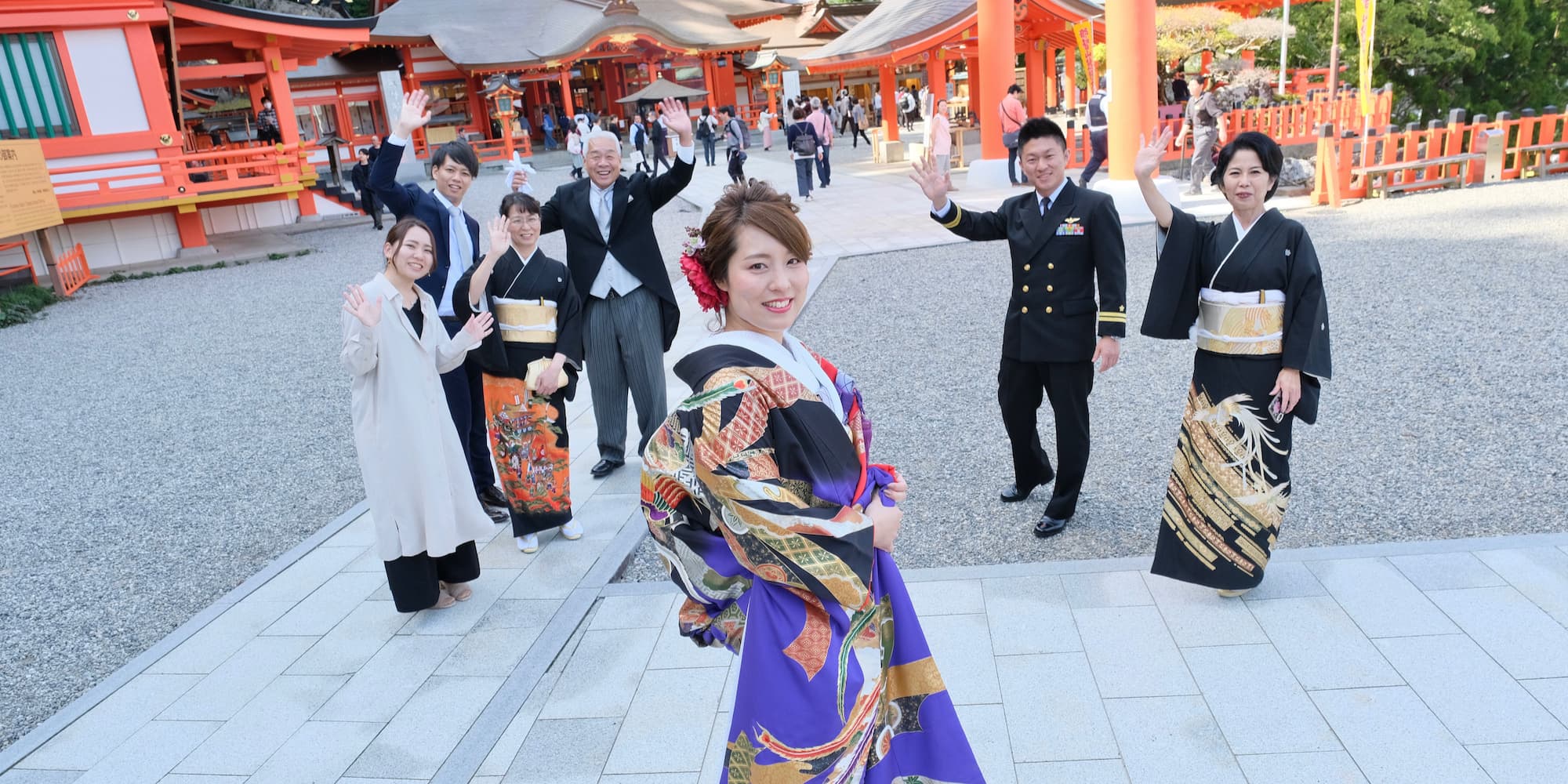 色打掛を着た花嫁様と紋付羽織袴を着た新郎様が神社で結婚式を挙げている
