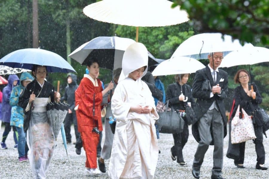 雨の日の大神神社を歩く白無垢姿の新郎新婦