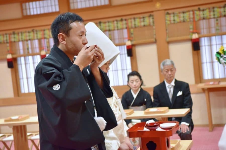 綿帽子と白無垢で神前結婚式を挙げる花嫁