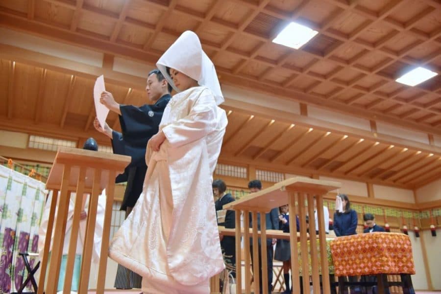 綿帽子と白無垢で神前結婚式を挙げる花嫁