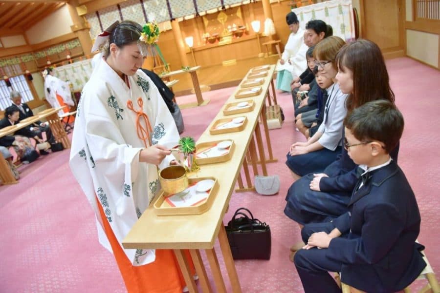 綿帽子と白無垢で神前結婚式を挙げる花嫁