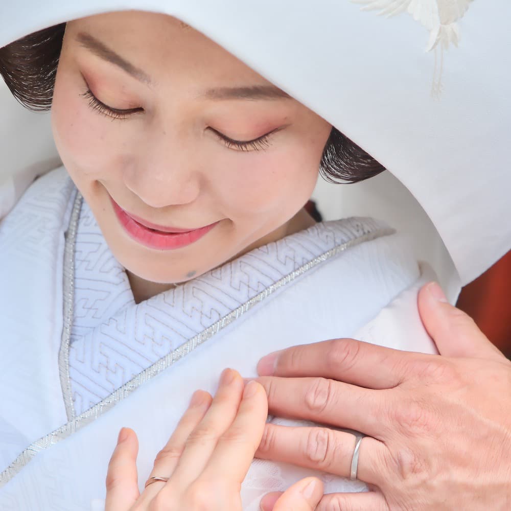 白無垢を着て綿帽子をつけた花嫁様が笑っている