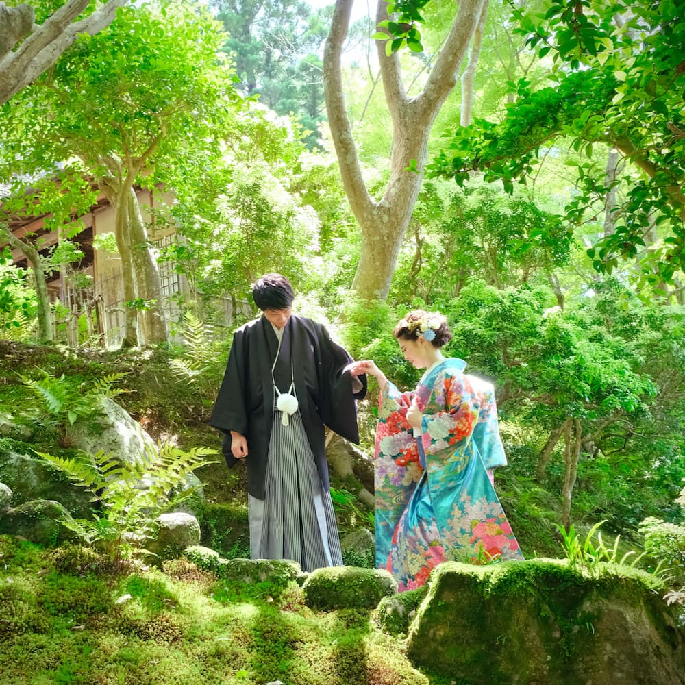 白無垢を着た花嫁様と紋付羽織袴を着た新郎様が神社で結婚式を挙げている