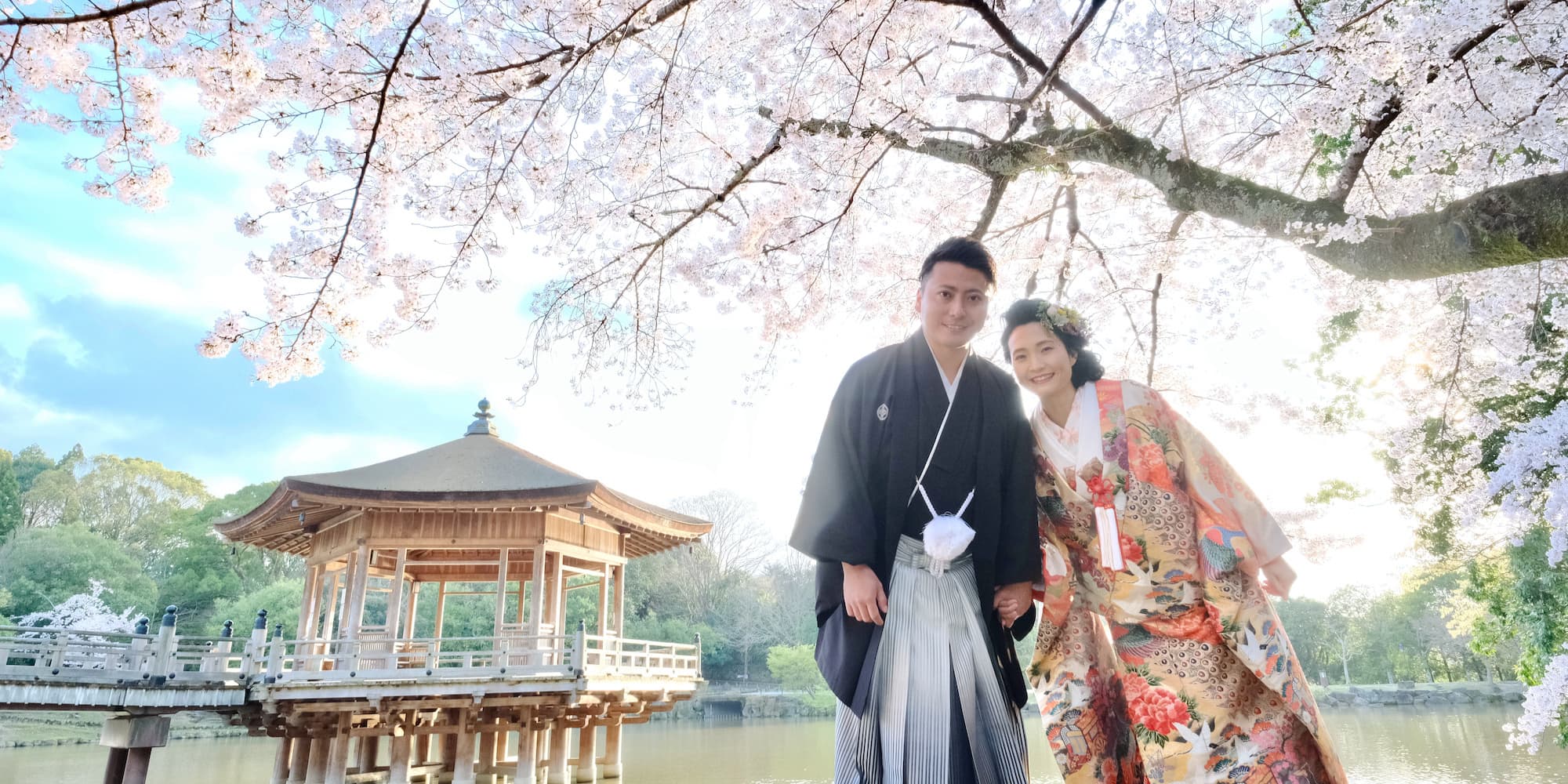 白無垢を着た花嫁様と紋付羽織袴を着た新郎様が寺院で結婚式を挙げている