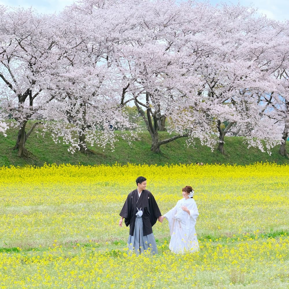 白無垢を着た花嫁様と紋付羽織袴を着た新郎様が神社で結婚式を挙げている