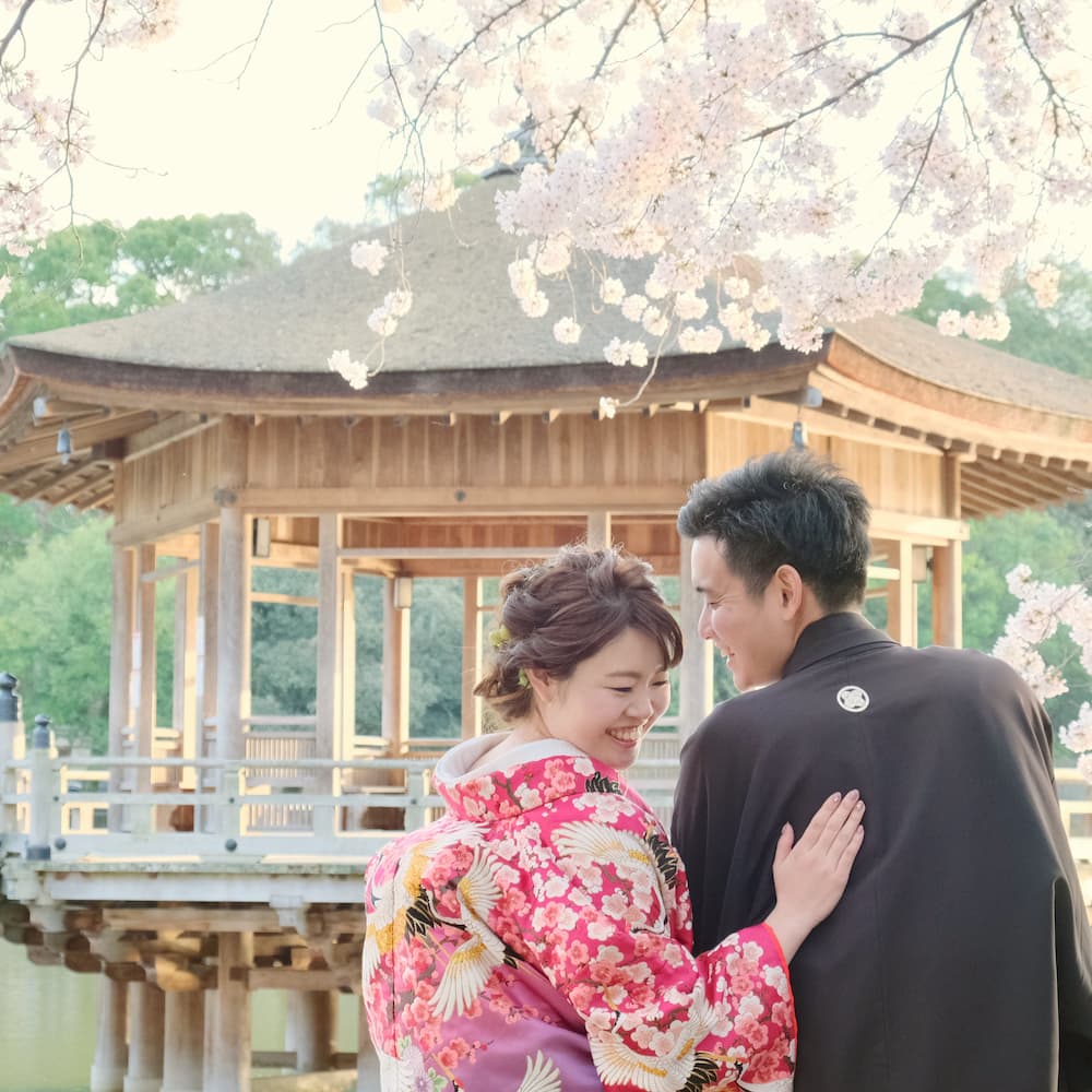 白無垢を着た花嫁様と紋付羽織袴を着た新郎様が神社で結婚式を挙げている