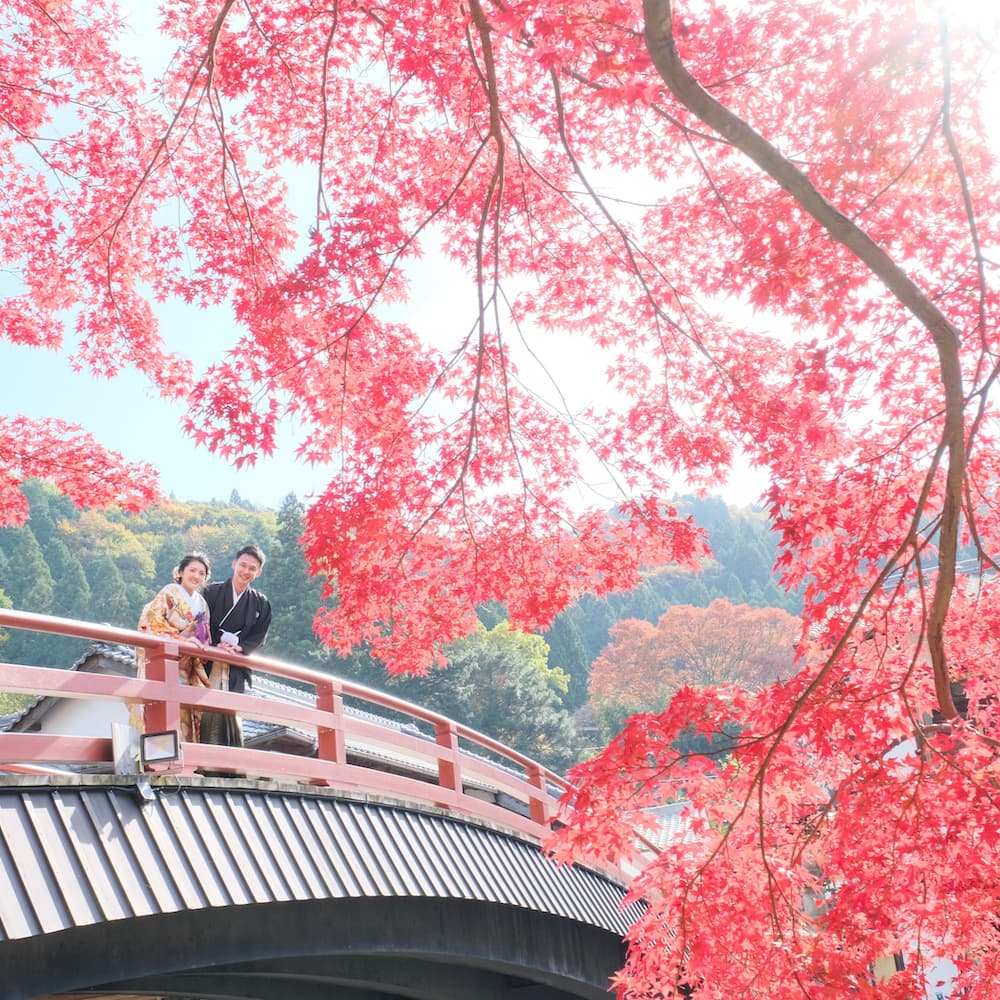 白無垢を着た花嫁様と紋付羽織袴を着た新郎様が神社で結婚式を挙げている