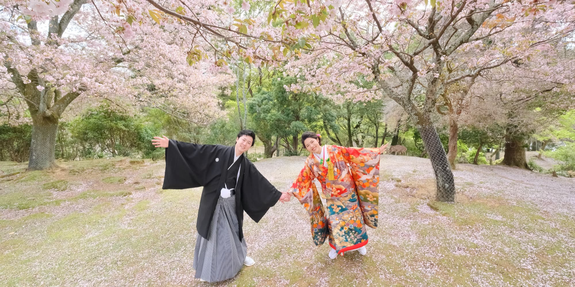 白無垢を着た花嫁様と紋付羽織袴を着た新郎様が神社で結婚式を挙げている