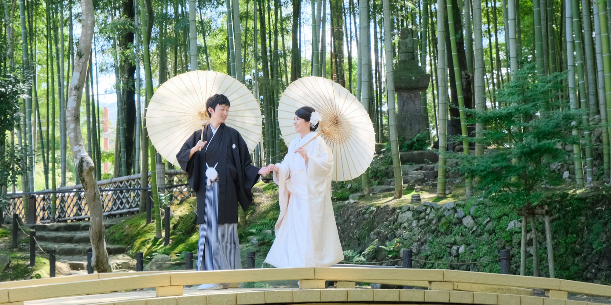 白無垢を着た花嫁様と紋付羽織袴を着た新郎様が神社で結婚式を挙げている