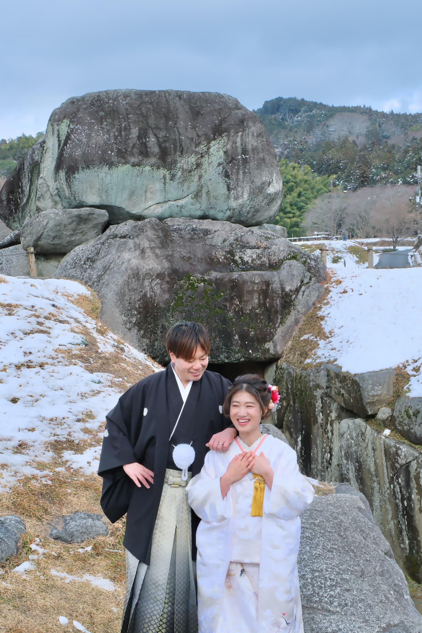 石舞台古墳の雪景色で撮影する白無垢と紋付袴の新郎新婦