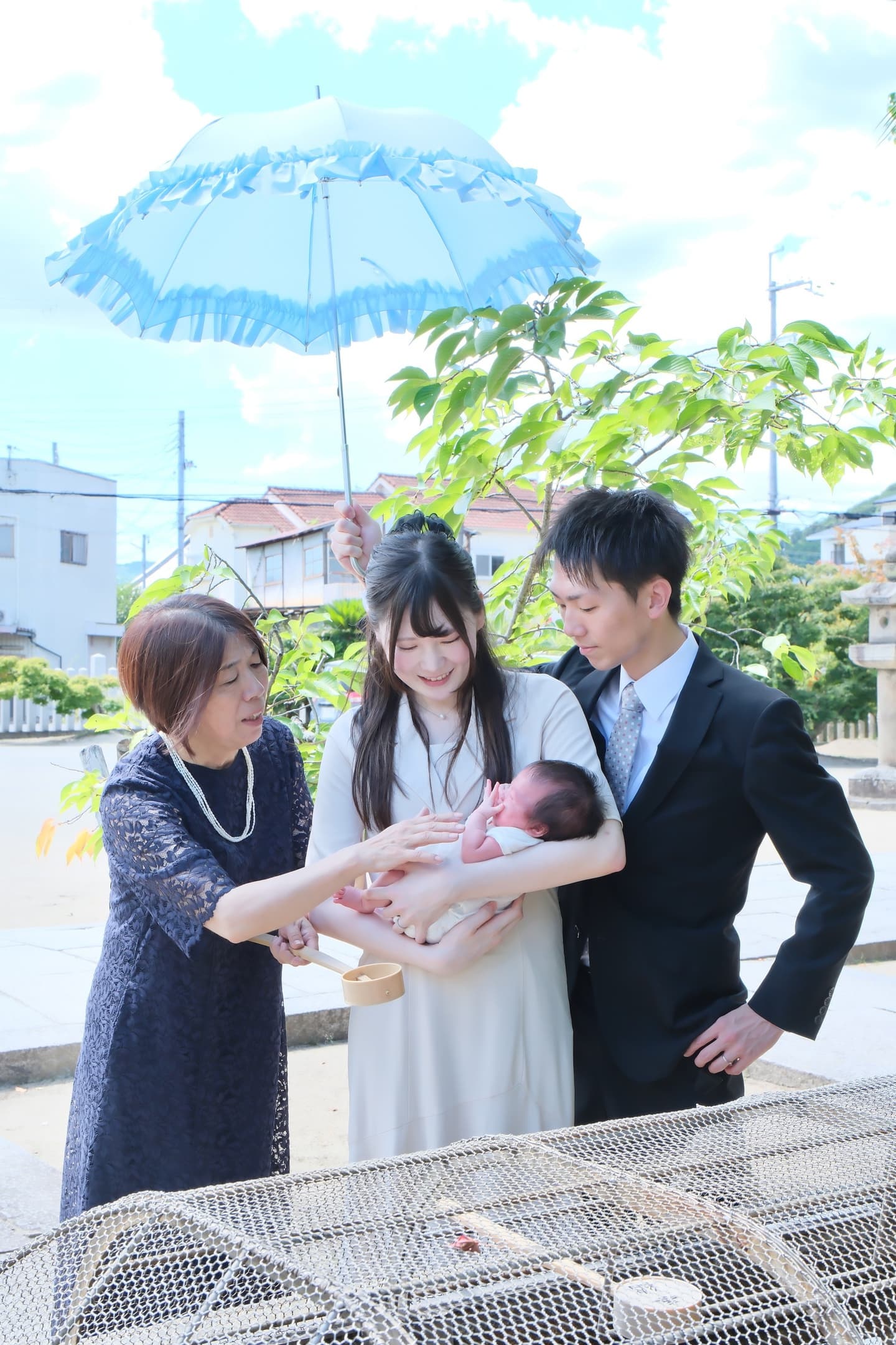 神社でお宮参りの赤ちゃんの家族写真