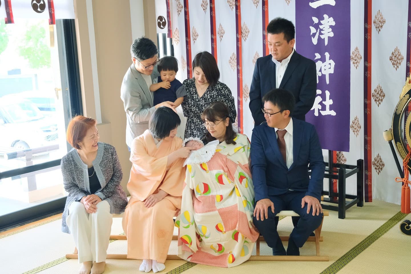 お宮参りの記念写真を撮る家族