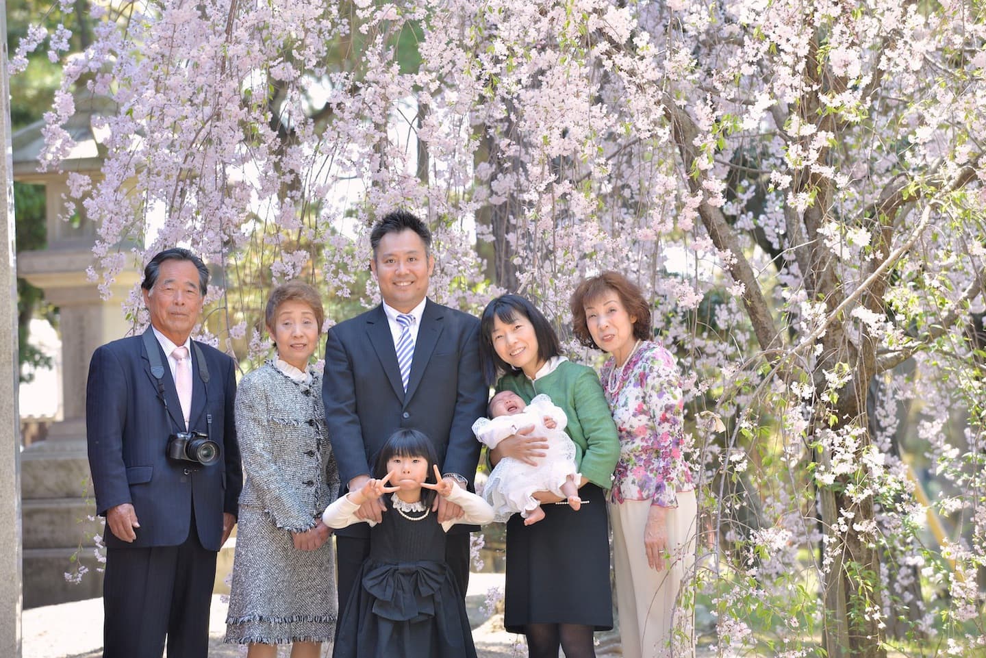 お宮参りの記念写真を撮っている家族
