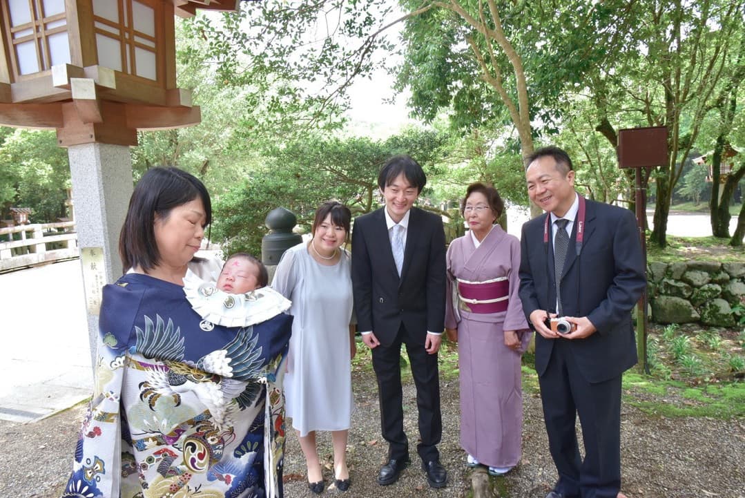 お宮参りでおばあちゃんが赤ちゃんを抱っこしている写真